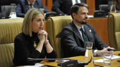 María Guardiola, sentada en su escaño de la Asamblea de Extremadura, junto a Abel Bautista, consejero de Presidencia. / LP
